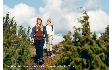 Two female hikers on a narrow trail