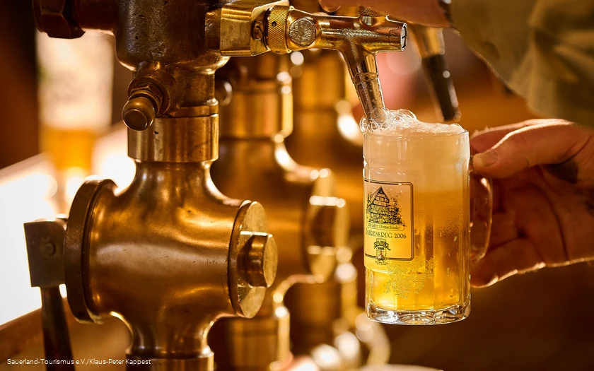 Ein schäumendes Bier wird frisch gezapft