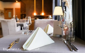 Ein mit gefalteten Servietten und Besteck eingedeckter Tisch in einem Restaurant.