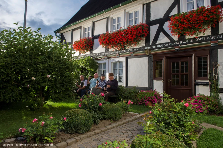 M&auml;nner trinken ein Feierabendbierchen vor Fachwerkkulisse