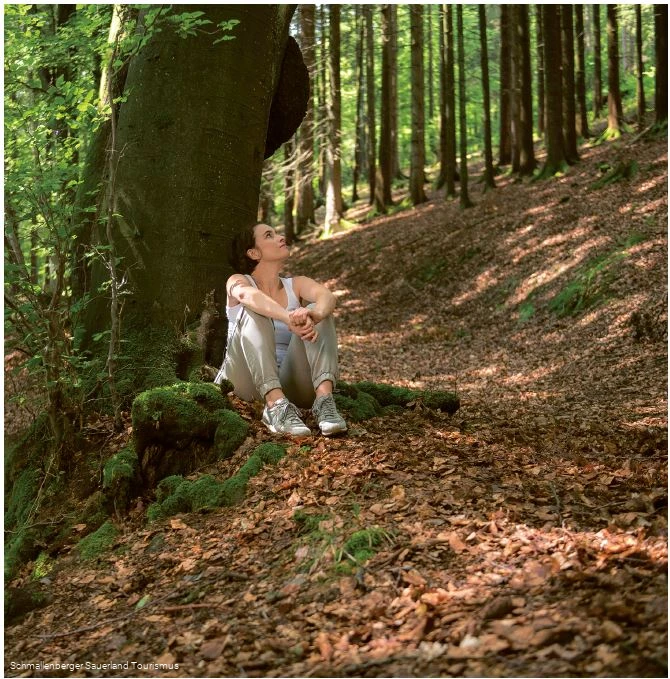 Eine Frau genie&szlig;t die Stille im Wald