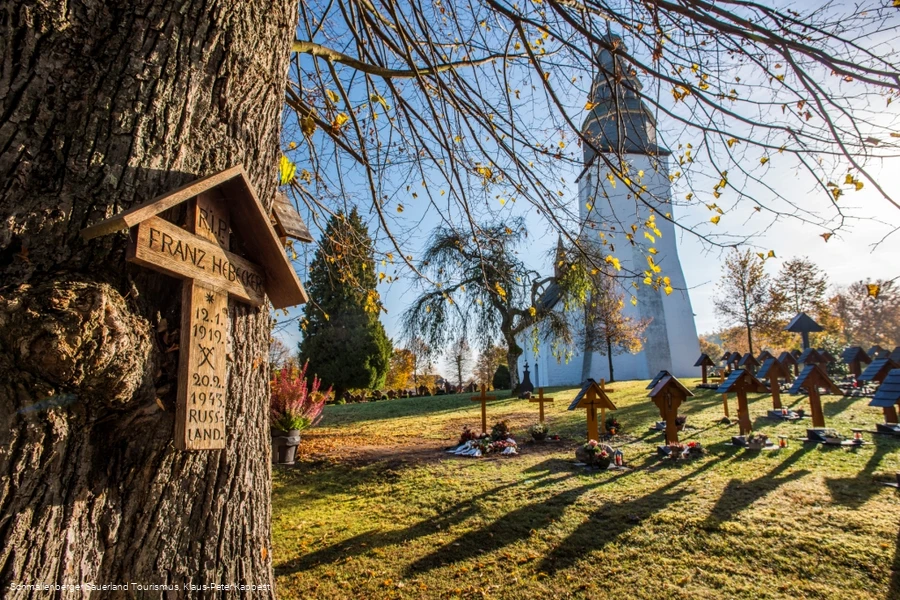 Sauerland-Wanderdörfer, Kirche in Wormbach mit Fokus auf einen Baum mit Kreuz